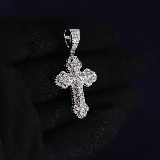 Silver cross pendant with clear stones on a dark background