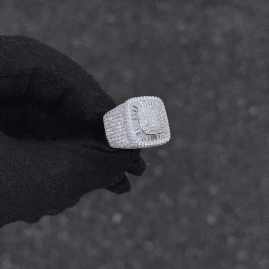 Silver ring with diamonds held by a gloved hand against a dark textured background