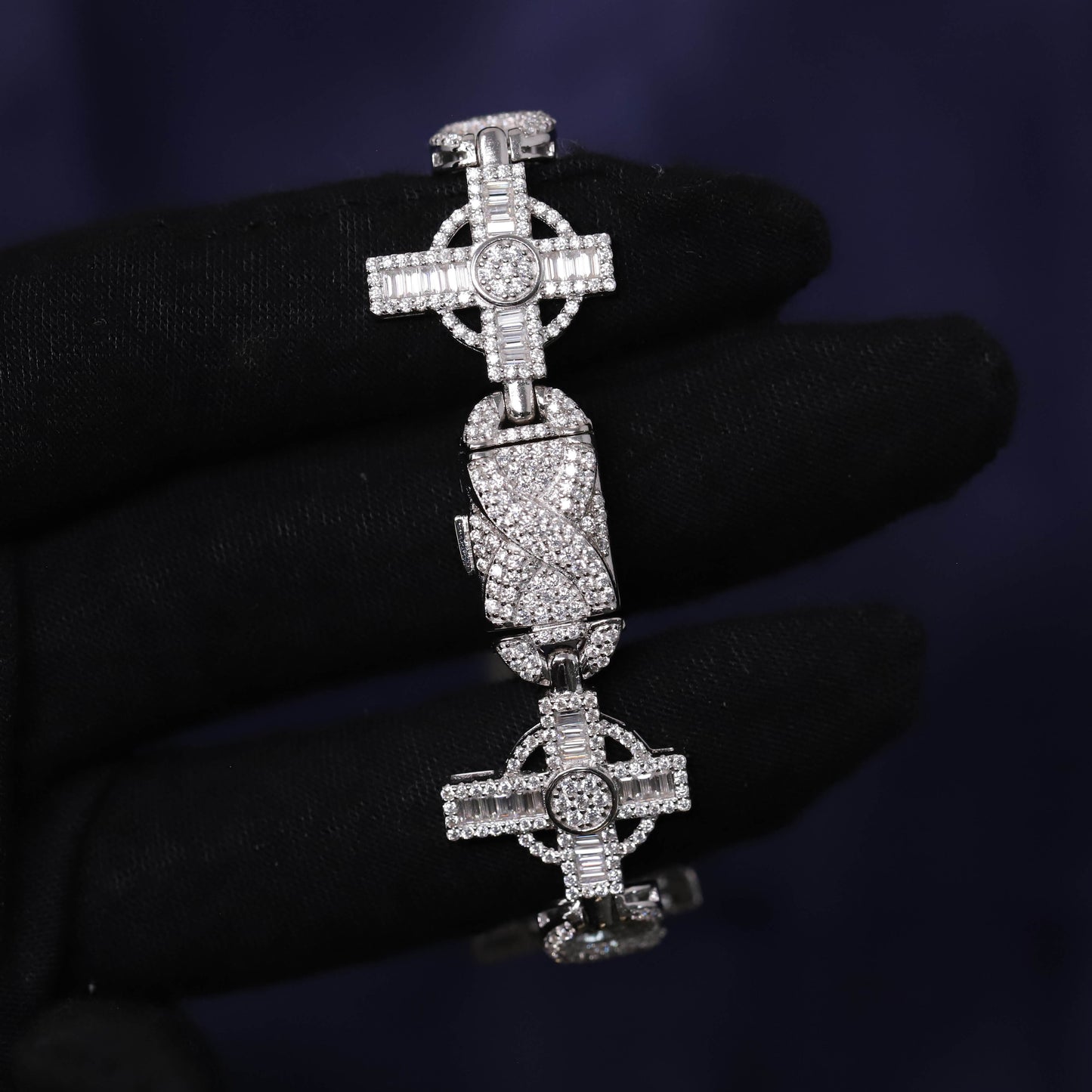 Silver cross pendant with gemstones on a dark background