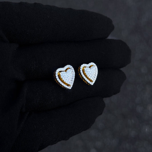 Gold heart moissanite cluster stud earrings shown on black glove with pavé detailing.