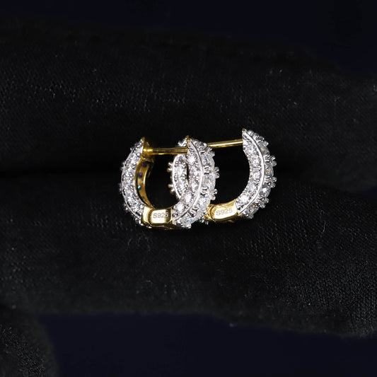Pair of gold and diamond hoop earrings on a black background
