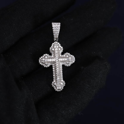 Silver cross pendant with clear stones on a black fabric background