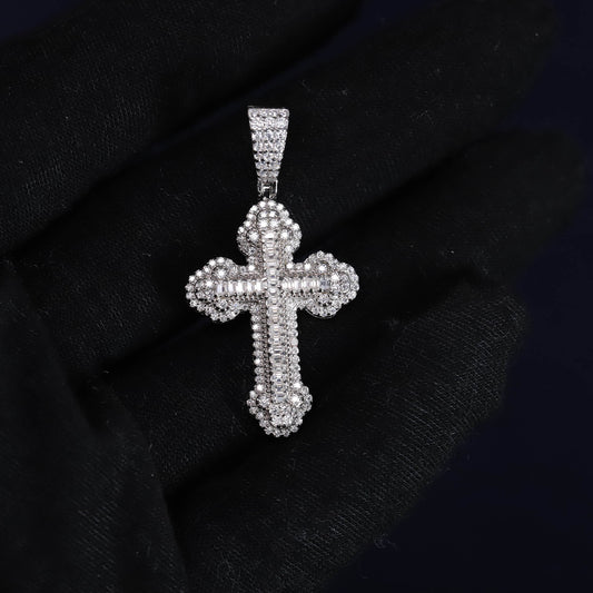 Silver cross pendant with clear stones on a black fabric background