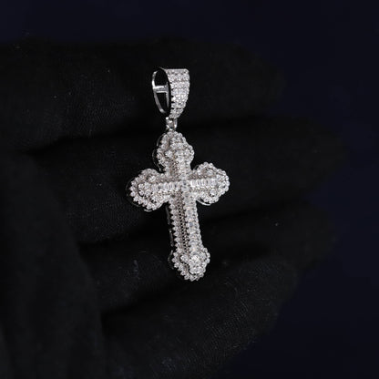 Silver cross pendant with clear stones on a dark background
