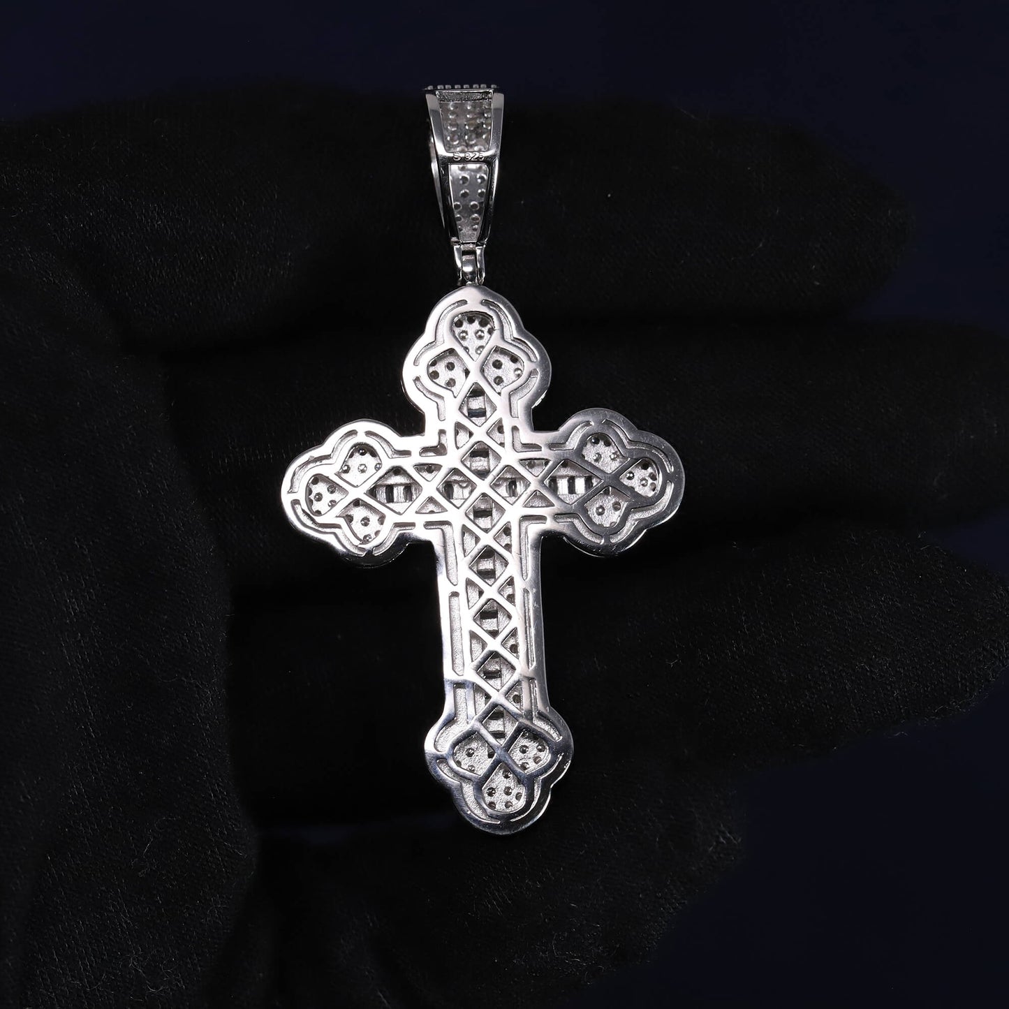 Silver cross pendant on a dark background