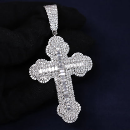 Silver cross pendant with clear stones on a dark background