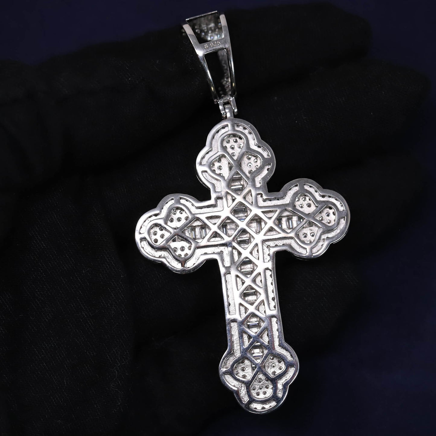 Silver cross pendant on a dark background