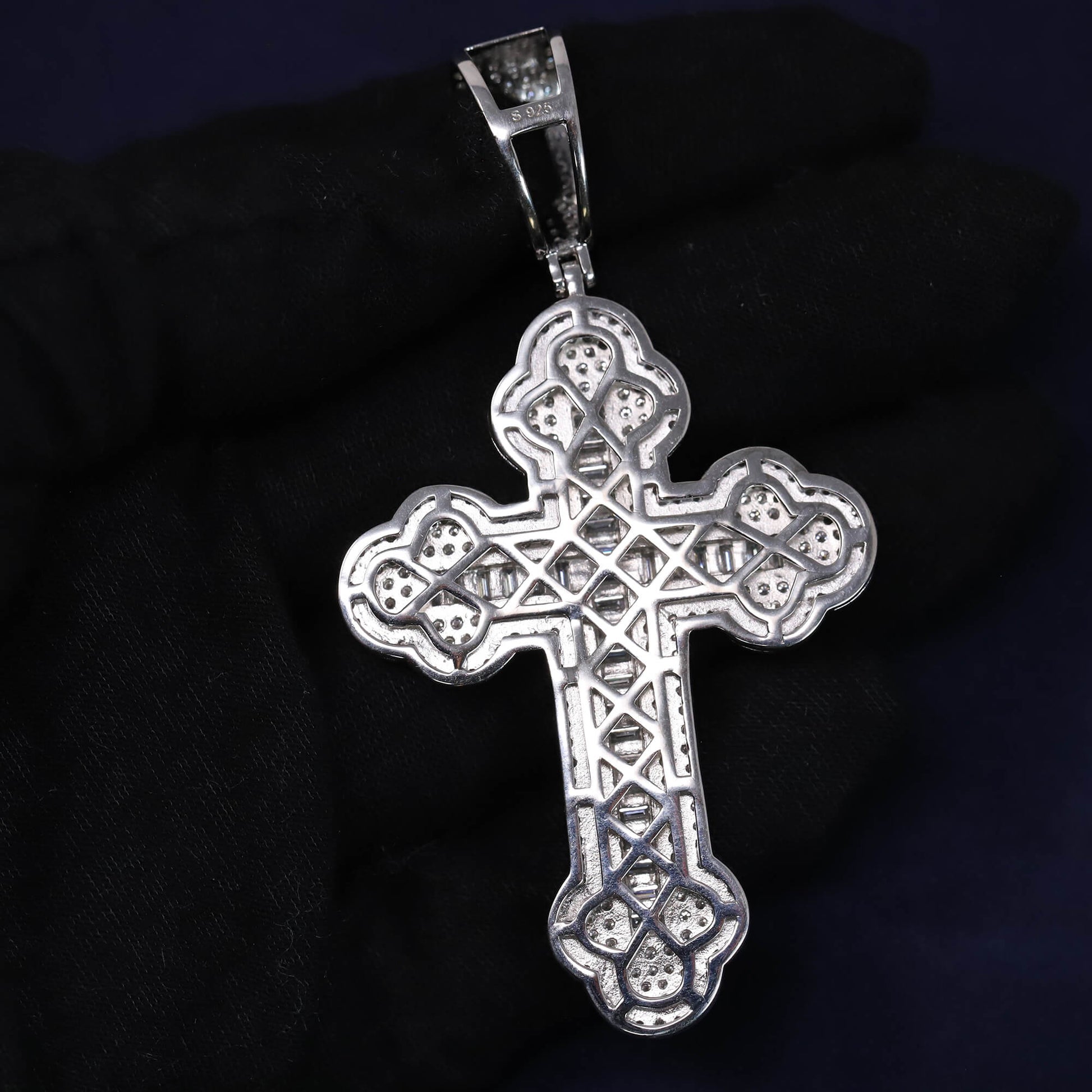 Silver cross pendant on a dark background
