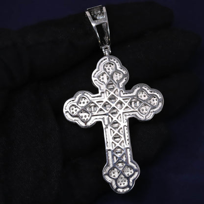 Silver cross pendant on a dark background