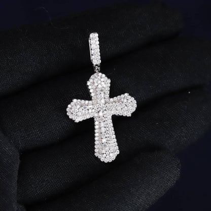Silver cross pendant on a black fabric background