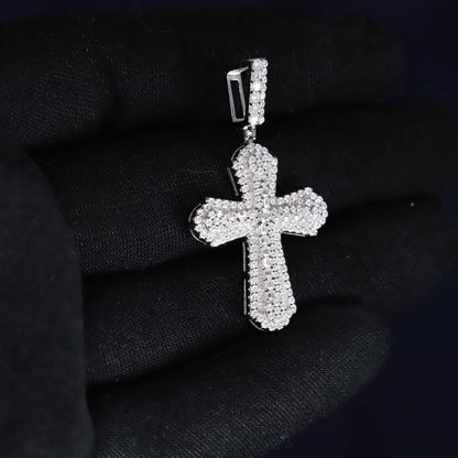 Silver cross pendant with clear stones on a black background