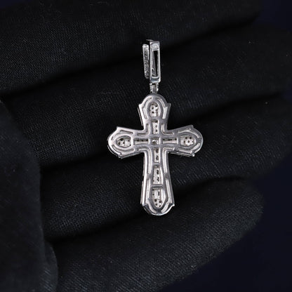 Silver cross pendant on a black fabric background