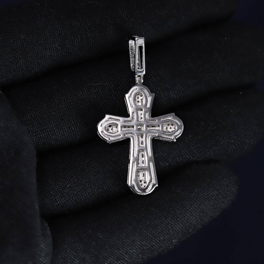 Silver cross pendant on a black fabric background