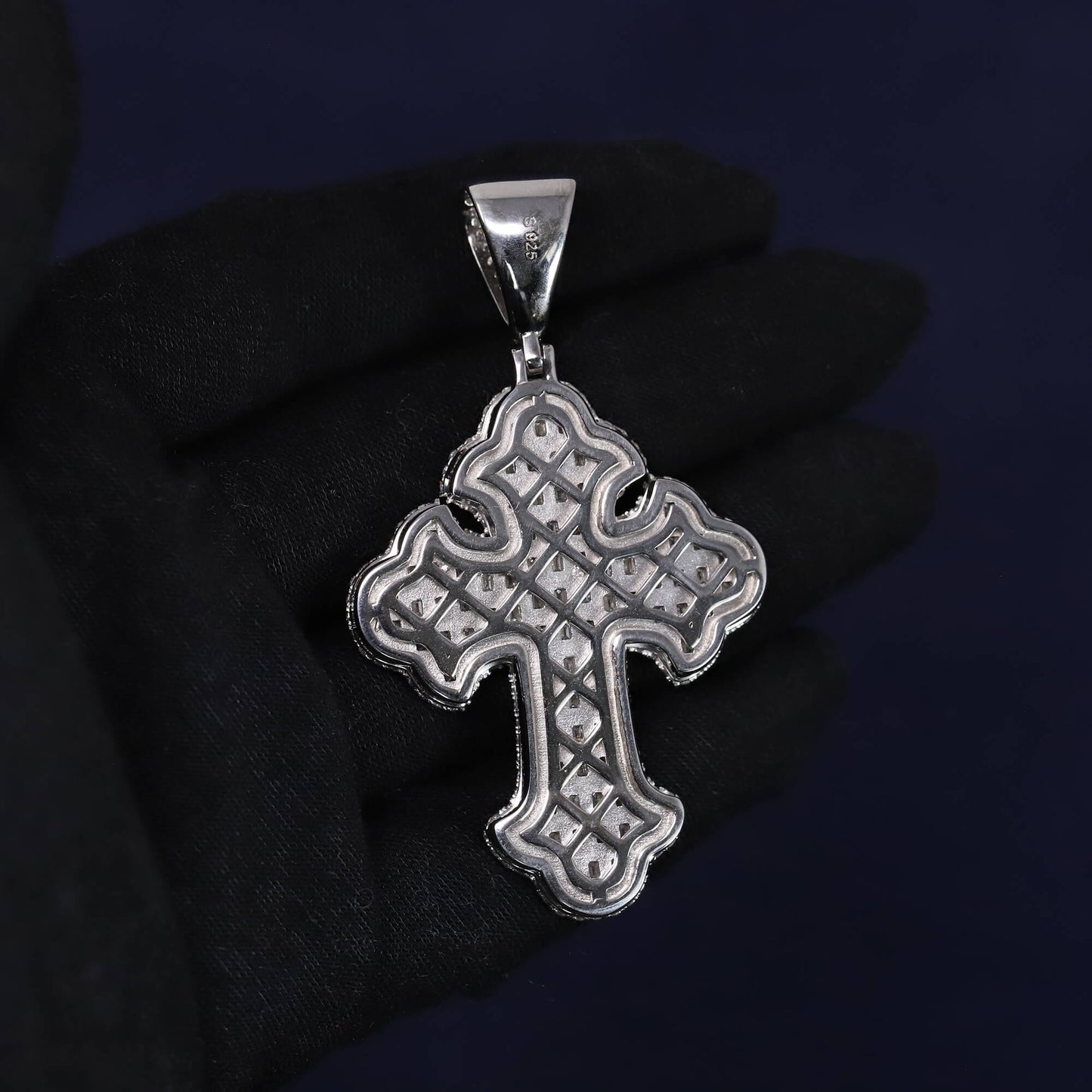 Silver cross pendant on a dark background