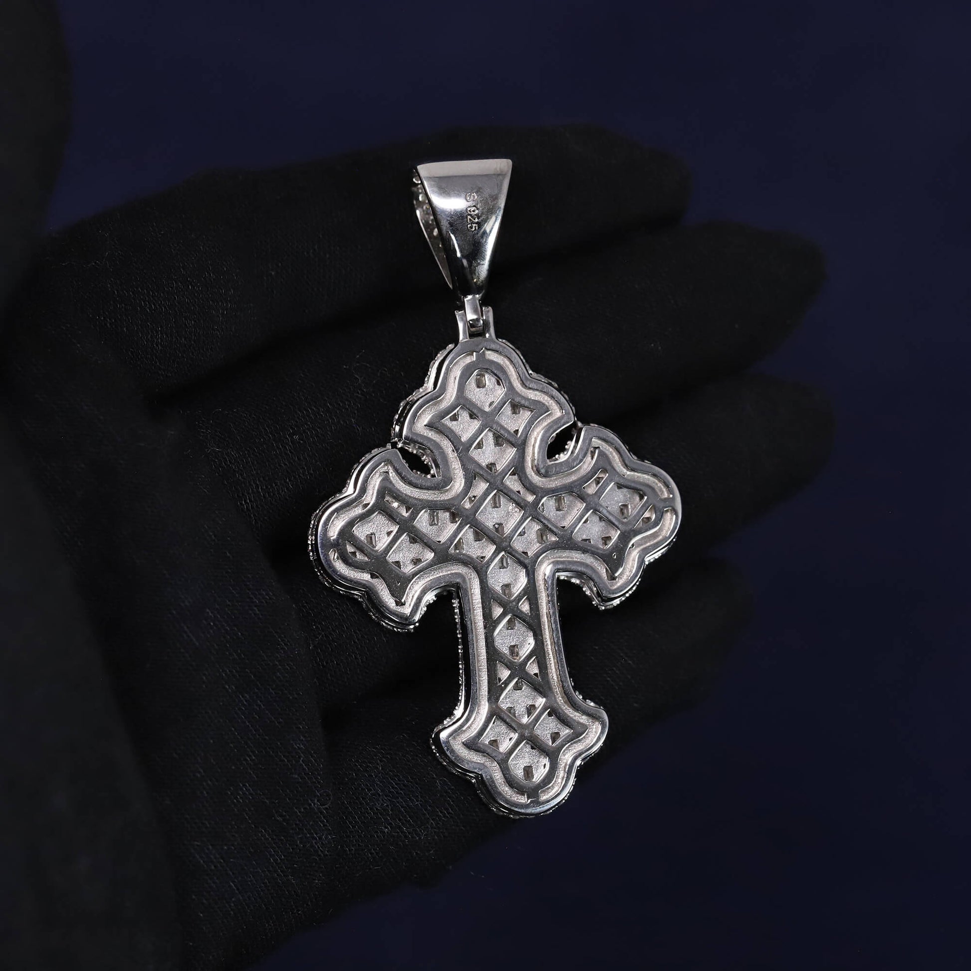Silver cross pendant on a dark background