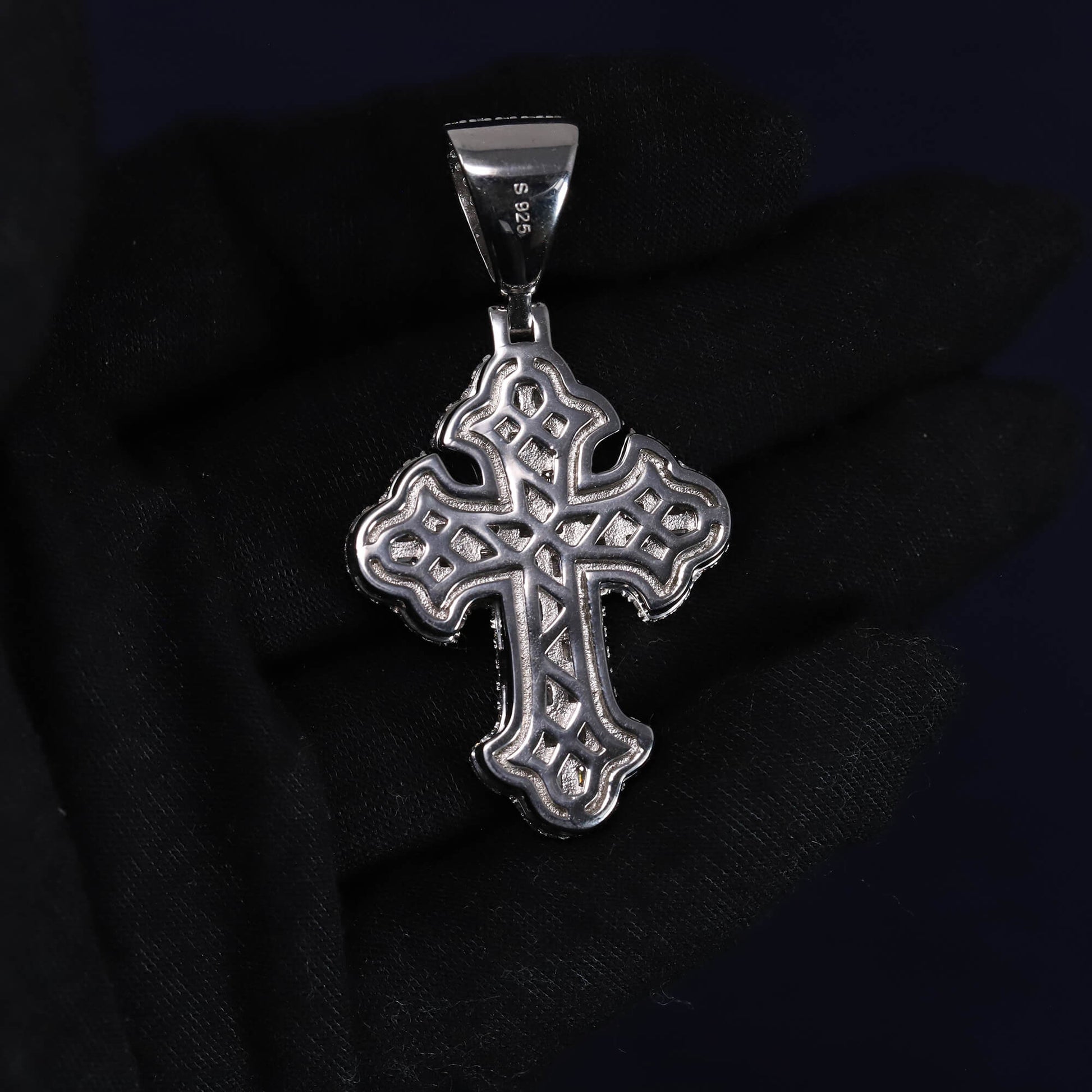 Silver cross pendant on a black background