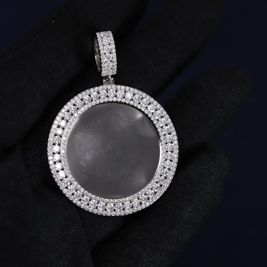 Silver pendant with a dark central stone on a black background