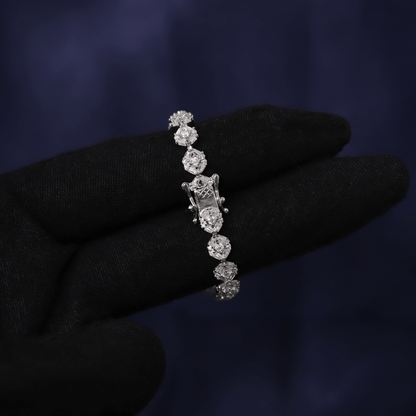 Diamond bracelet held by a gloved hand against a dark background