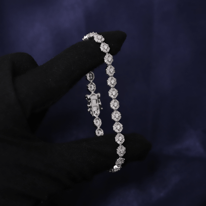 Diamond bracelet held by a hand against a dark background