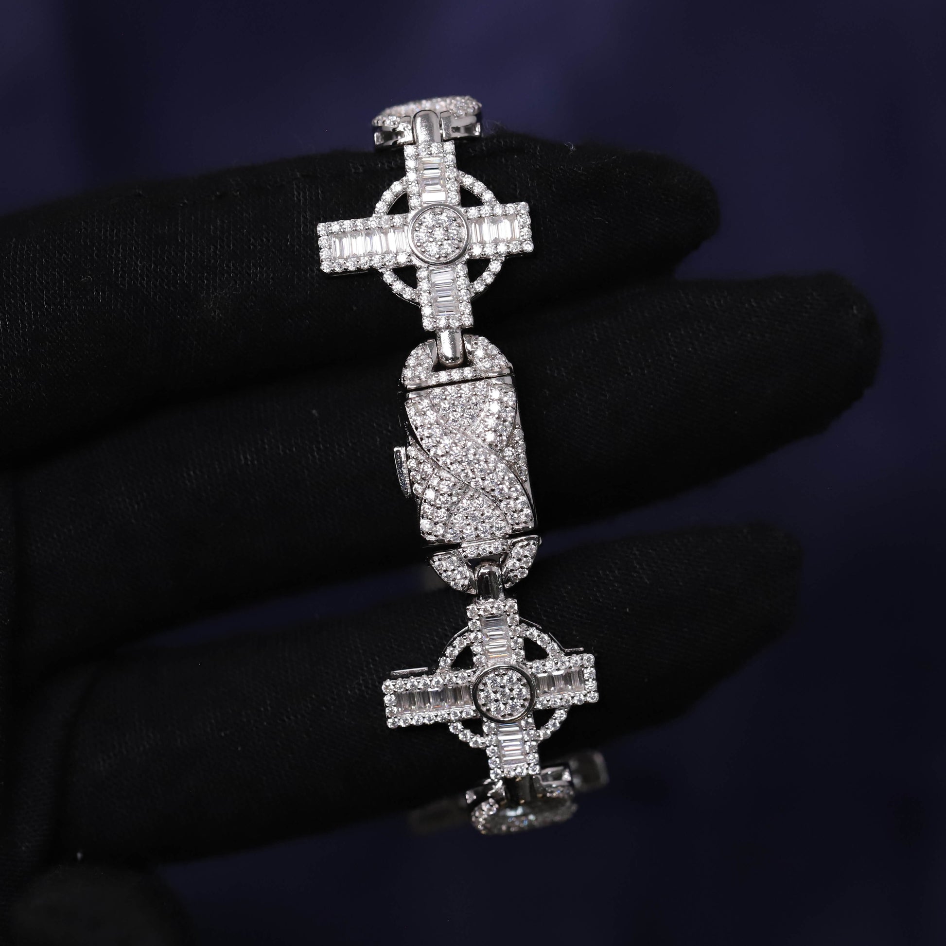 Silver cross pendant with gemstones on a dark background