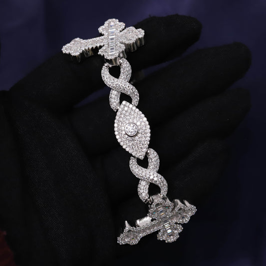 Silver bracelet with intricate design held by a gloved hand against a dark background