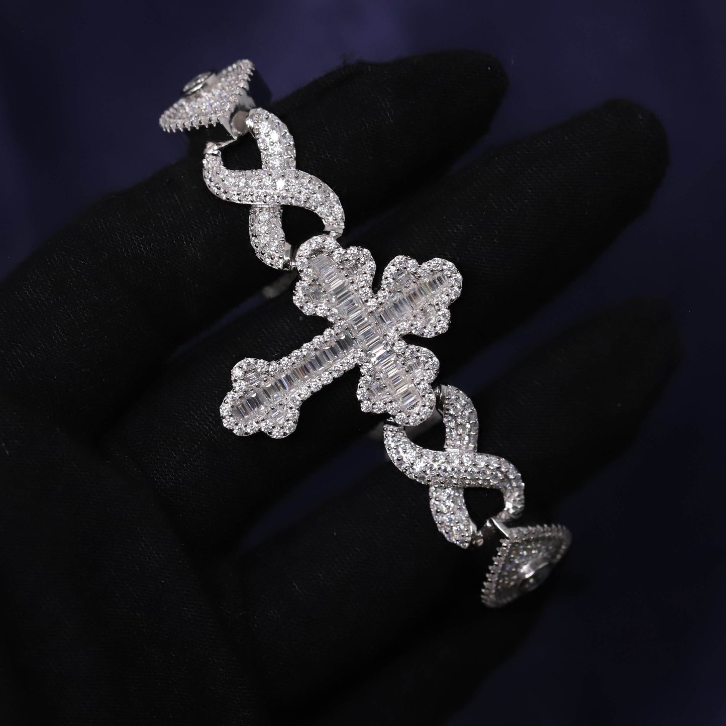 Silver earring with intricate design on a dark background