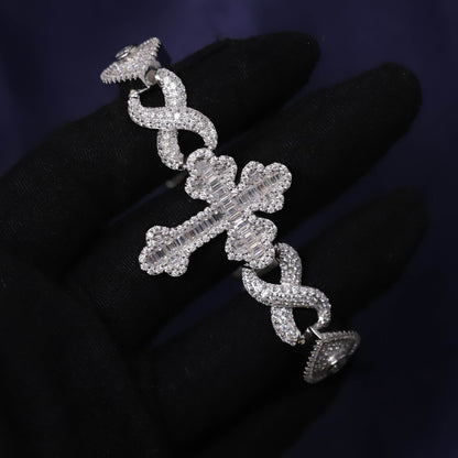 Silver earring with intricate design on a dark background