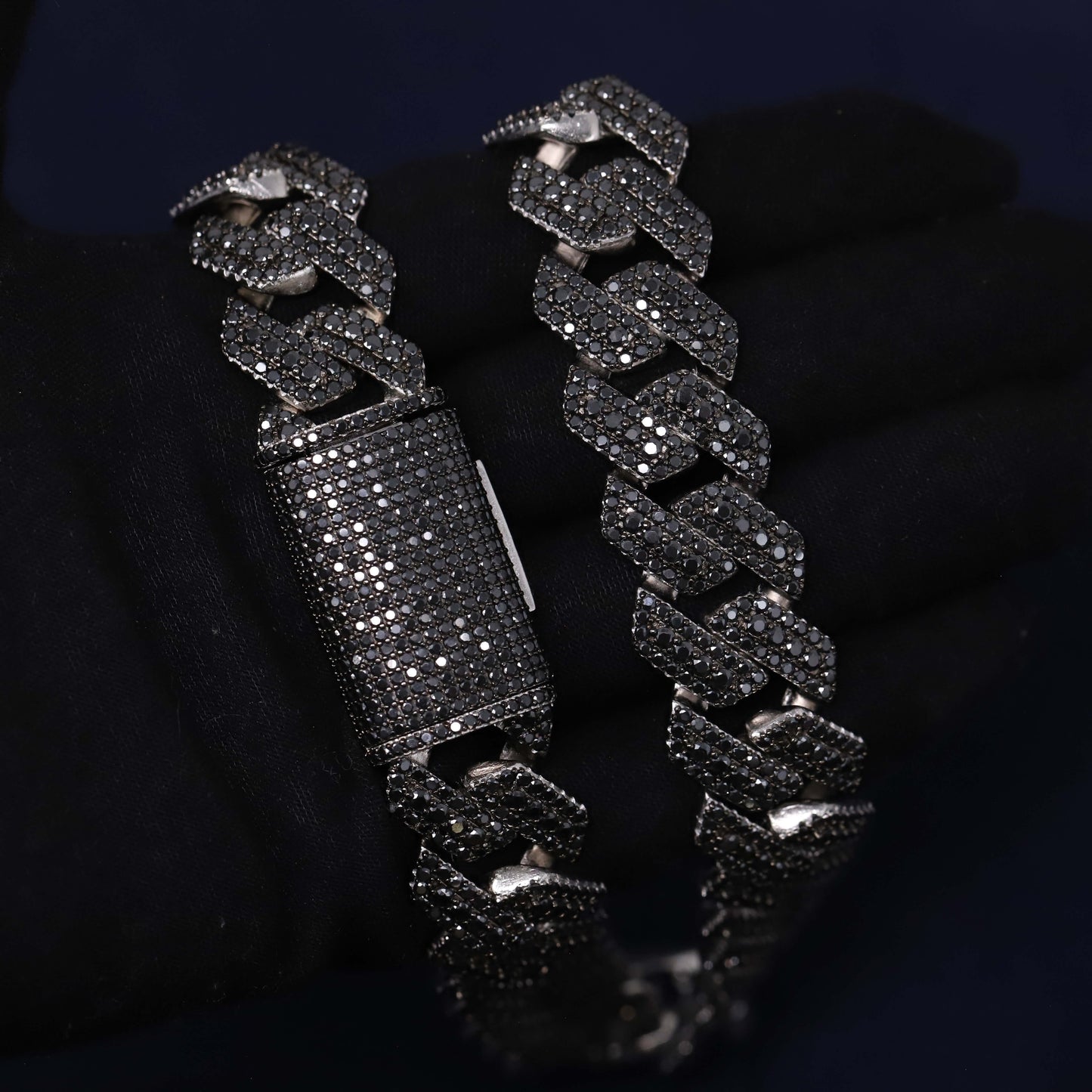 Black chain bracelet with diamond-like stones on a dark background