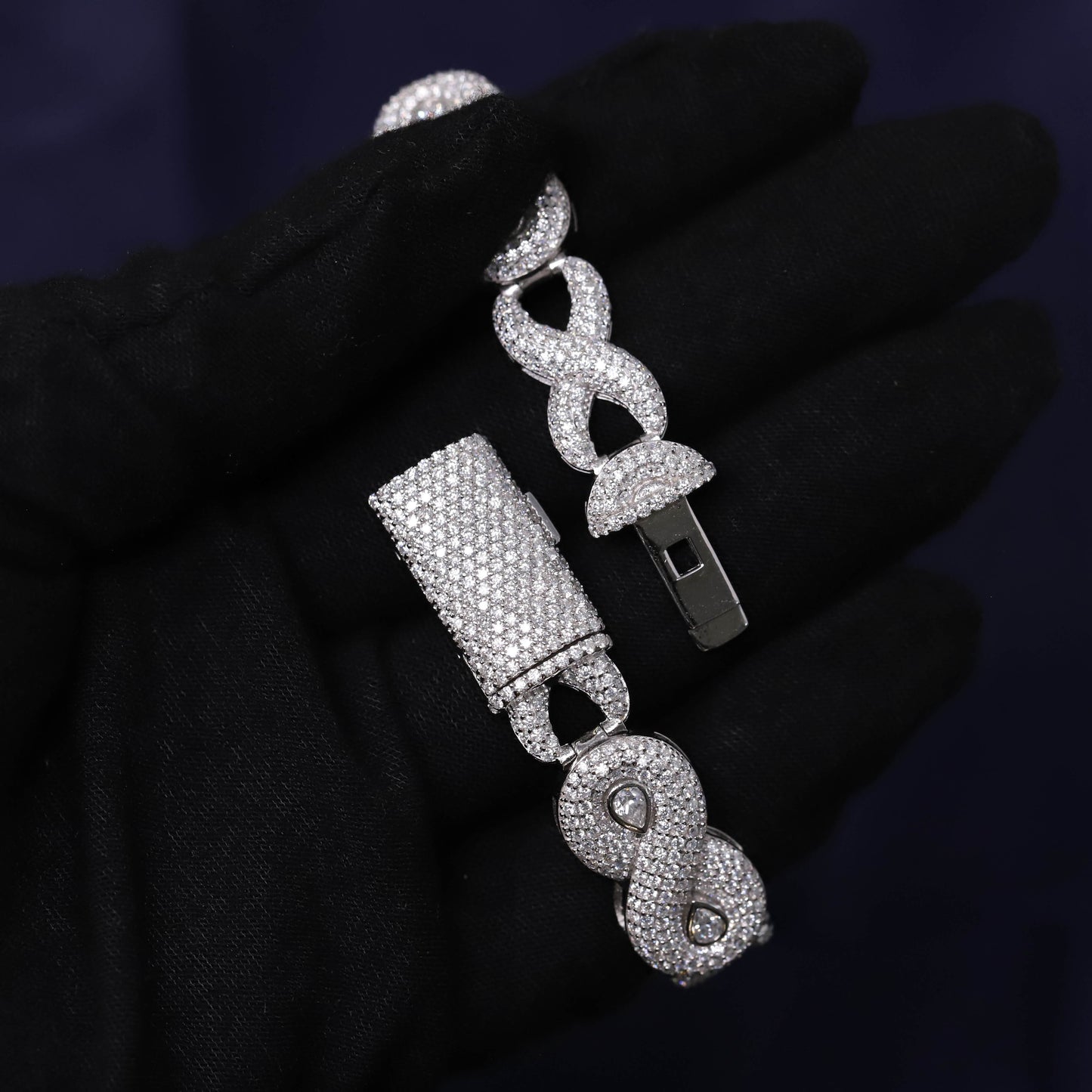 Silver jewelry set with bell and infinity design on a dark background