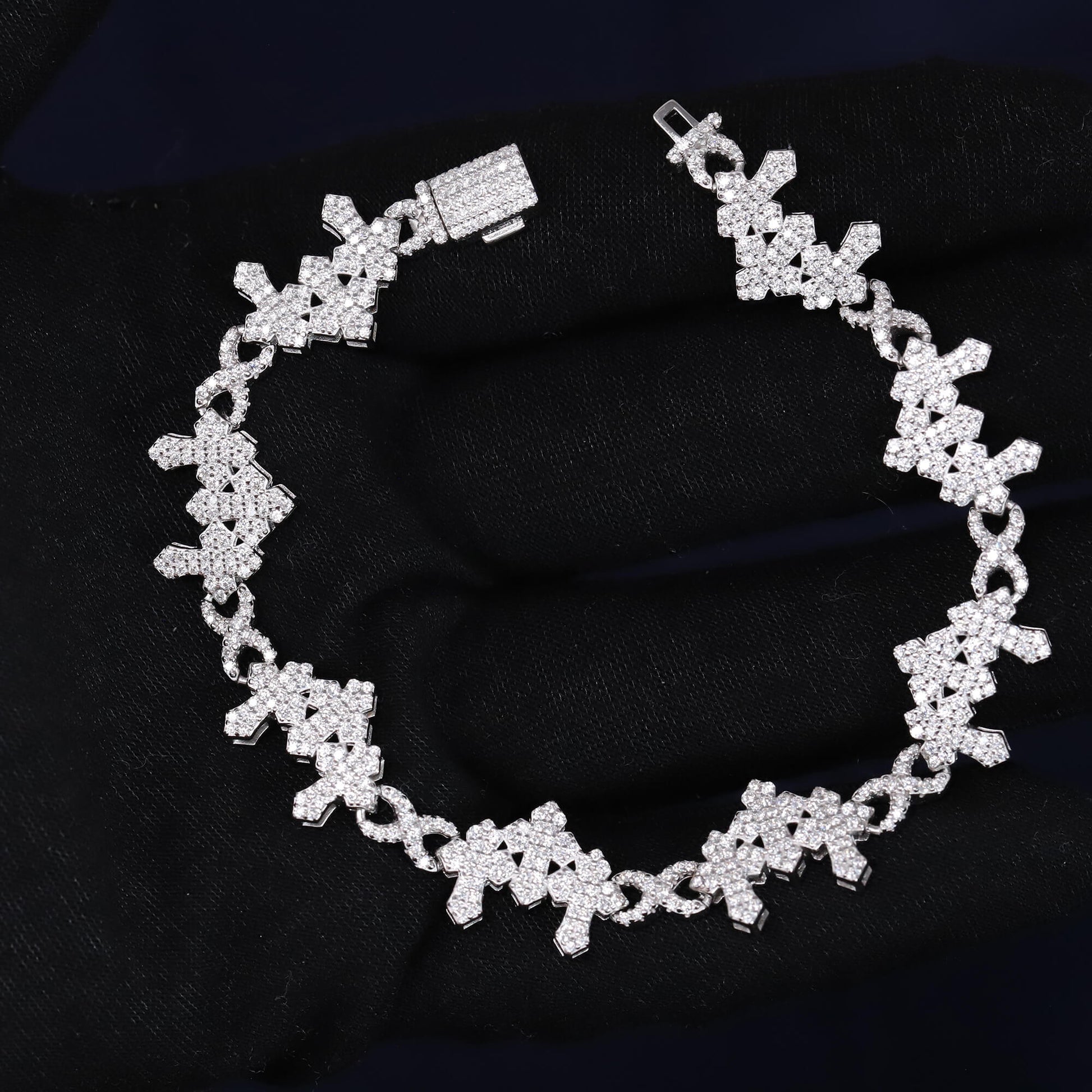 Silver bracelet with floral design on a black fabric background