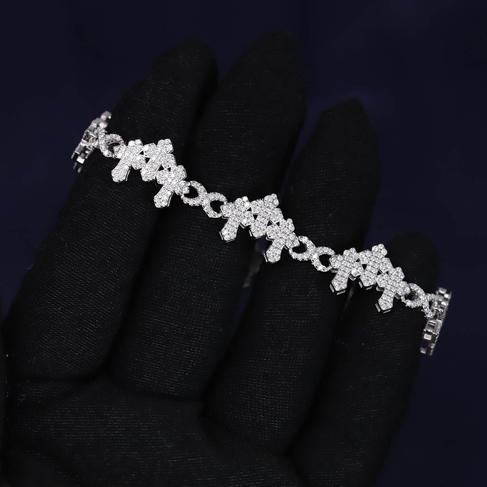 Silver bracelet with clear stones on a black glove against a dark background