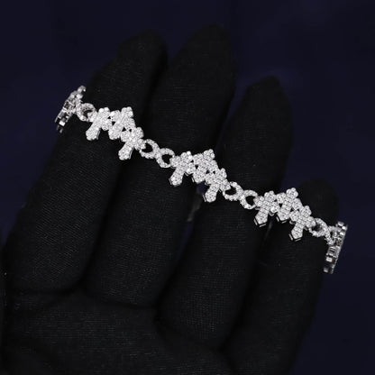 Silver bracelet with clear stones on a black glove against a dark background