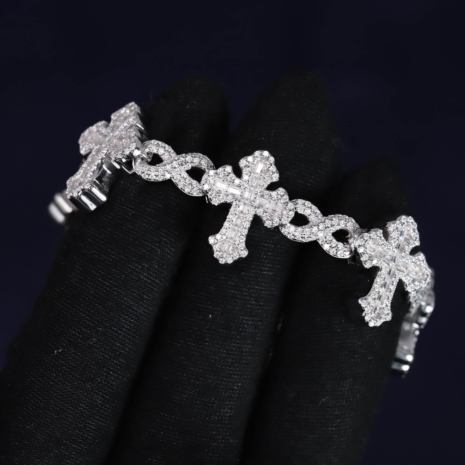 Silver bracelet with cross designs on a black background