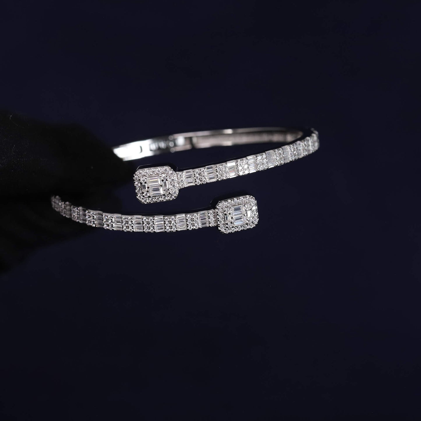 Silver bracelet with diamond accents on a dark background