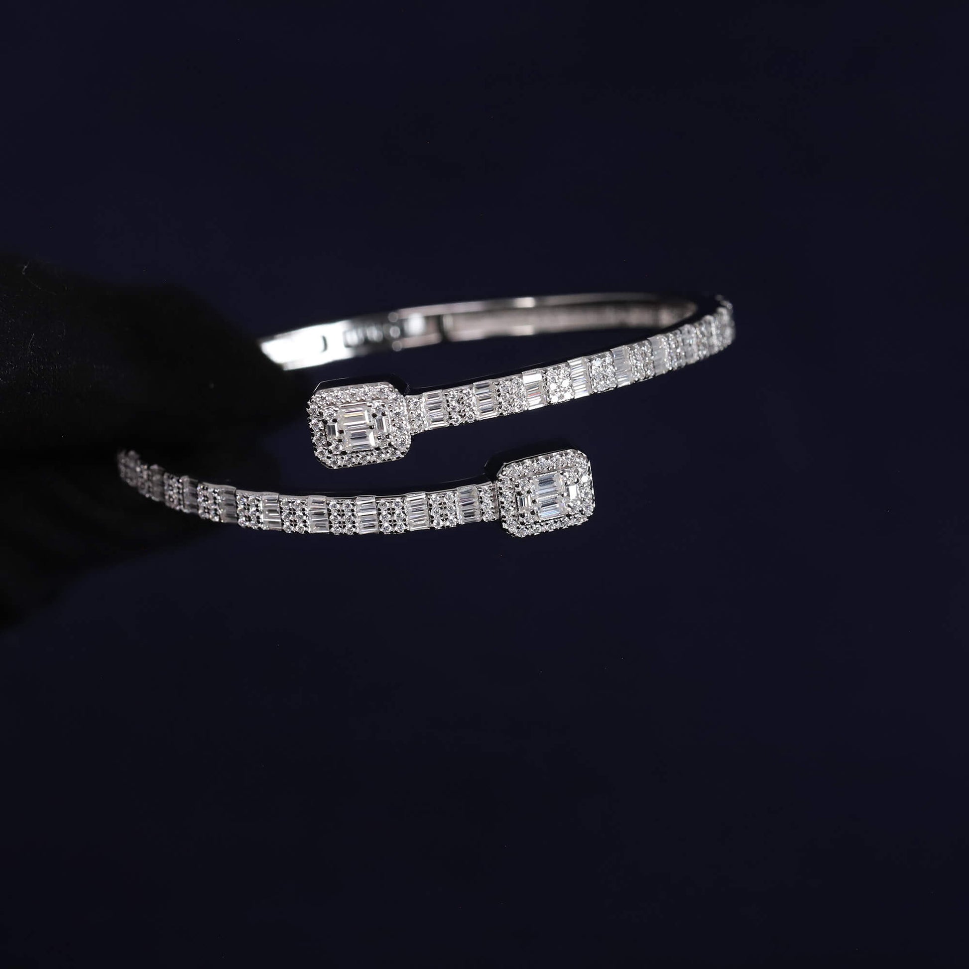 Silver bracelet with diamond accents on a dark background