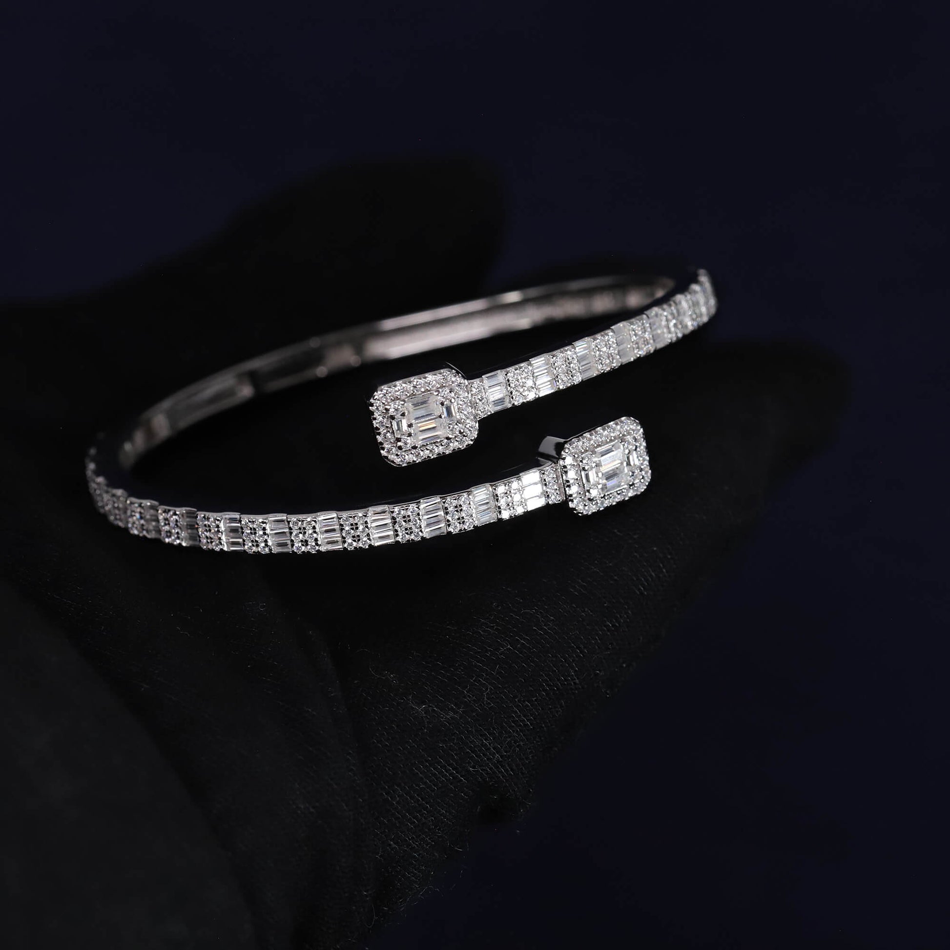 Silver bracelet with diamond accents on a dark background