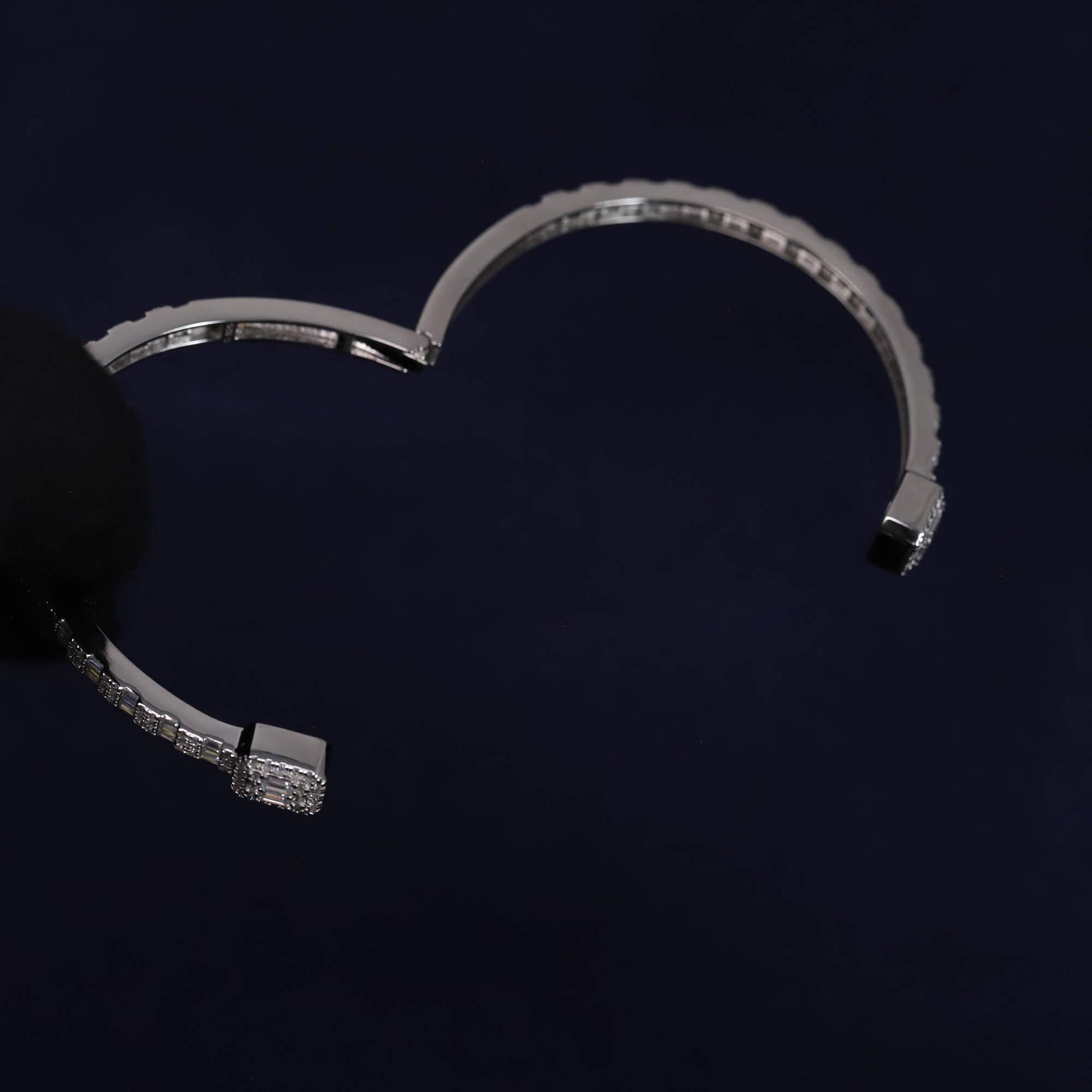 Silver bracelet with diamond accents on a dark background