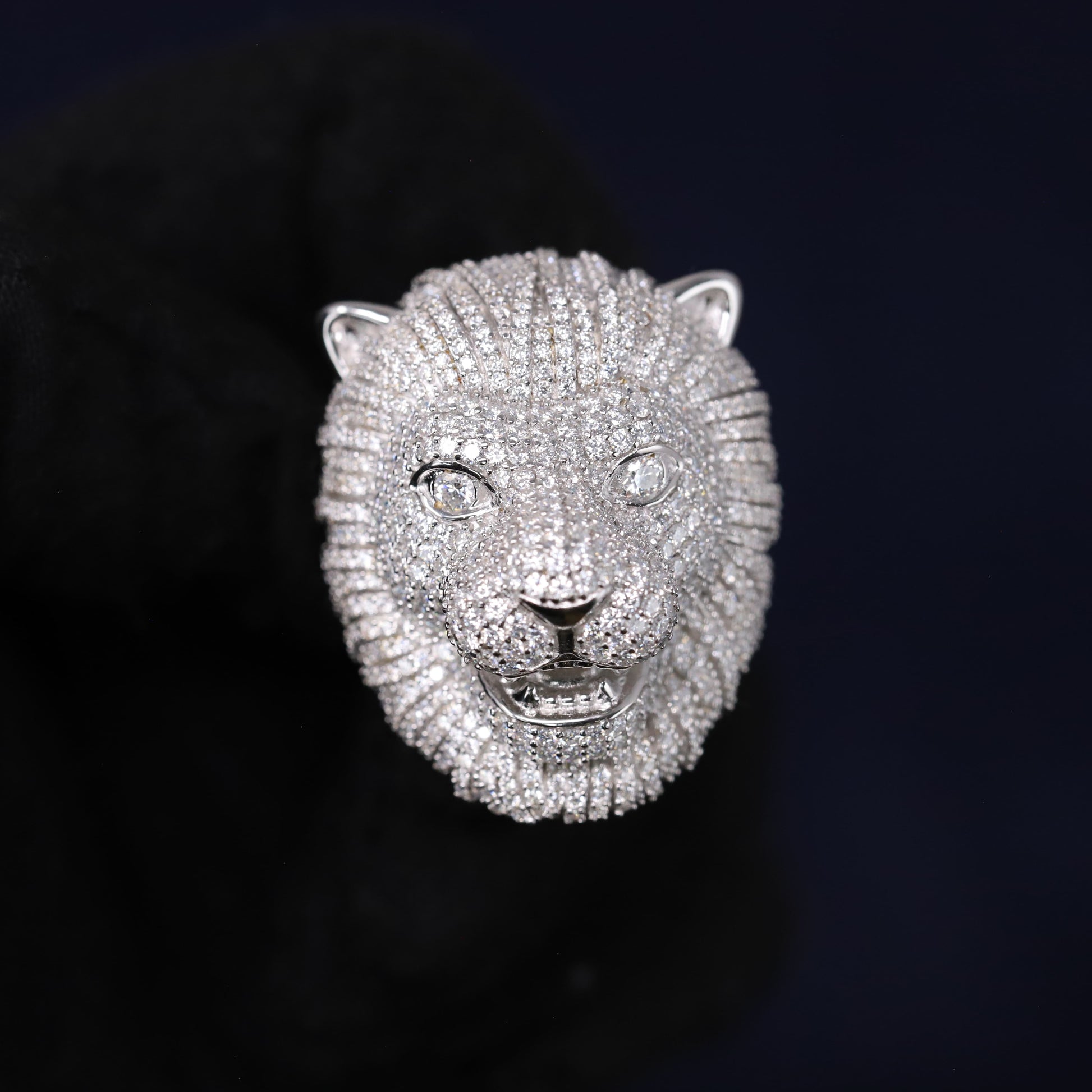 Silver lion head sculpture on a black background