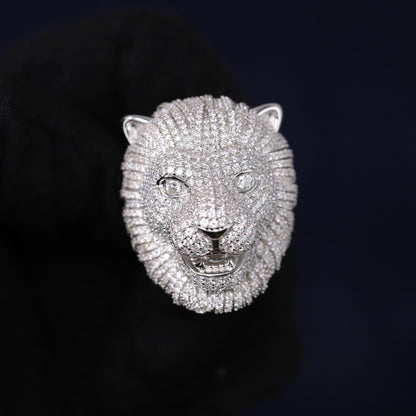 Silver lion head sculpture on a black background