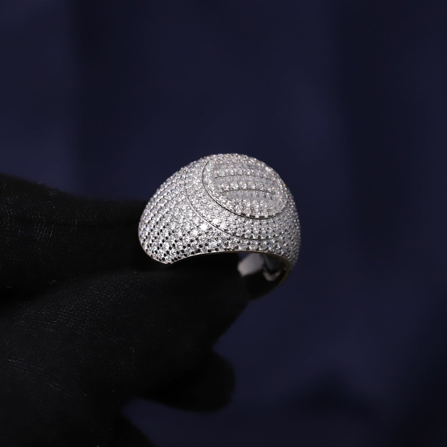 Silver ring with intricate design on a dark background