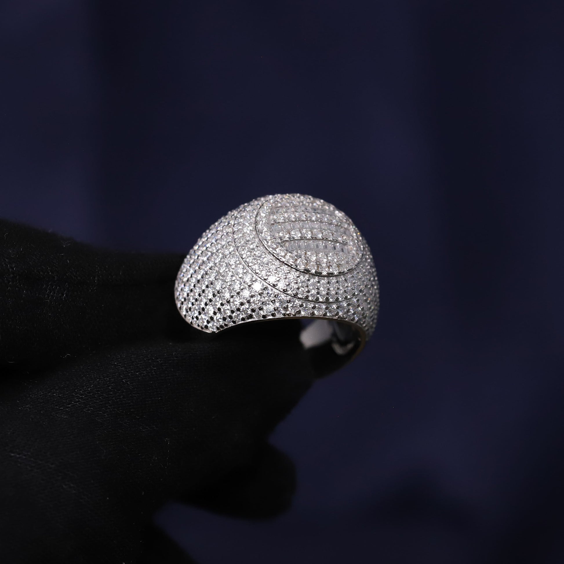 Silver ring with intricate design on a dark background