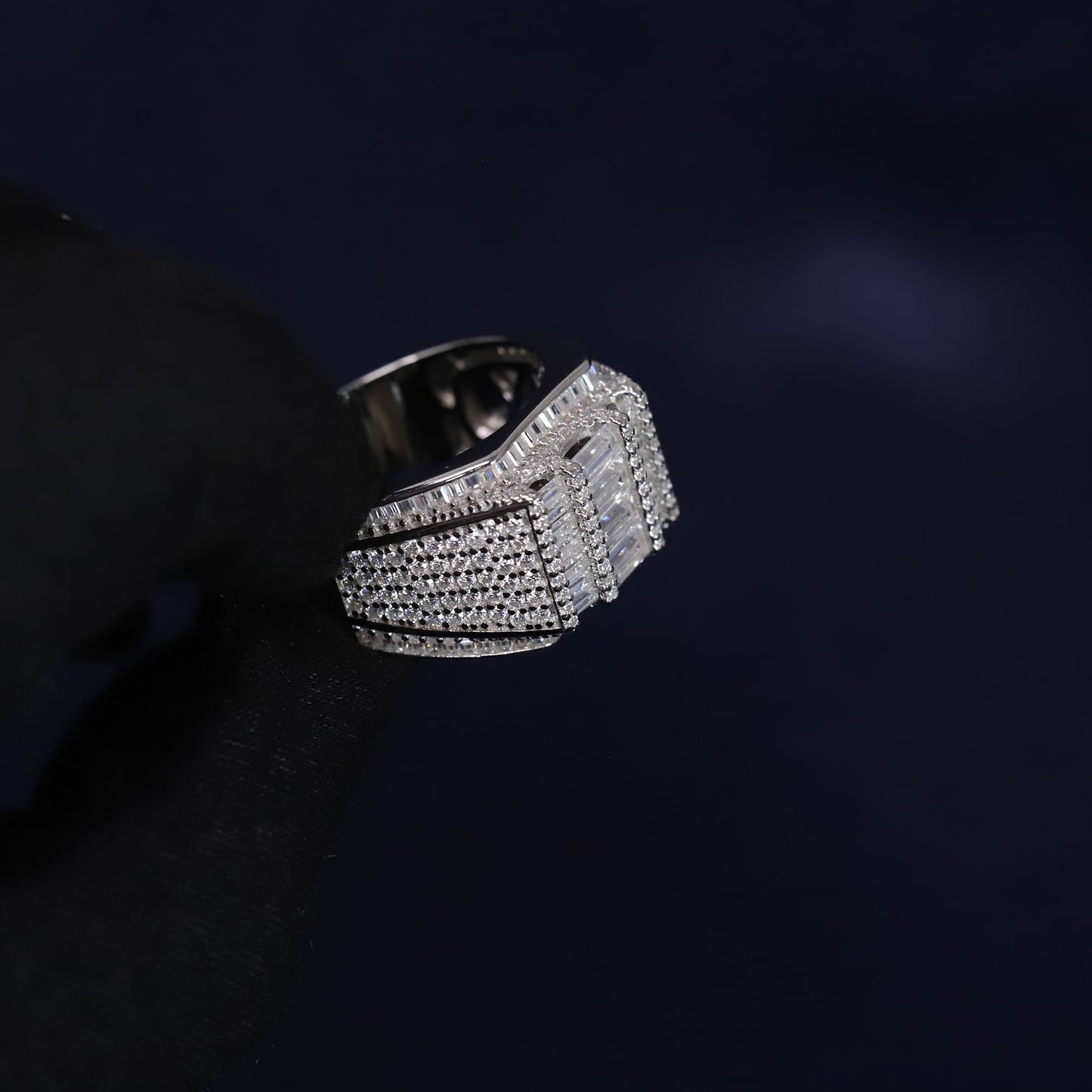 Silver ring with intricate design on a dark background