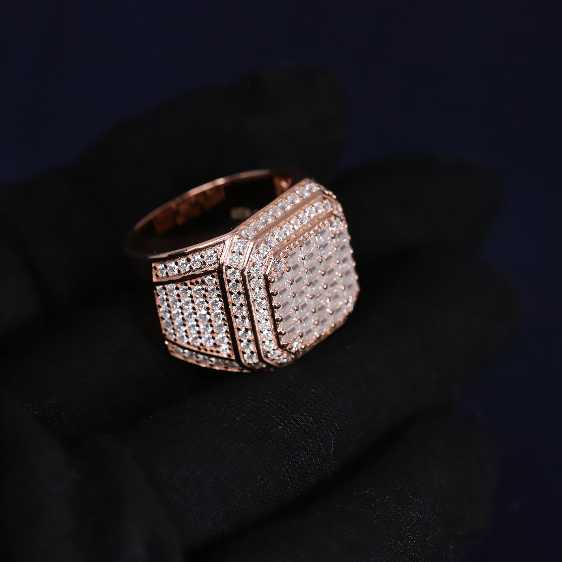 Rose gold ring with diamond accents on a dark background