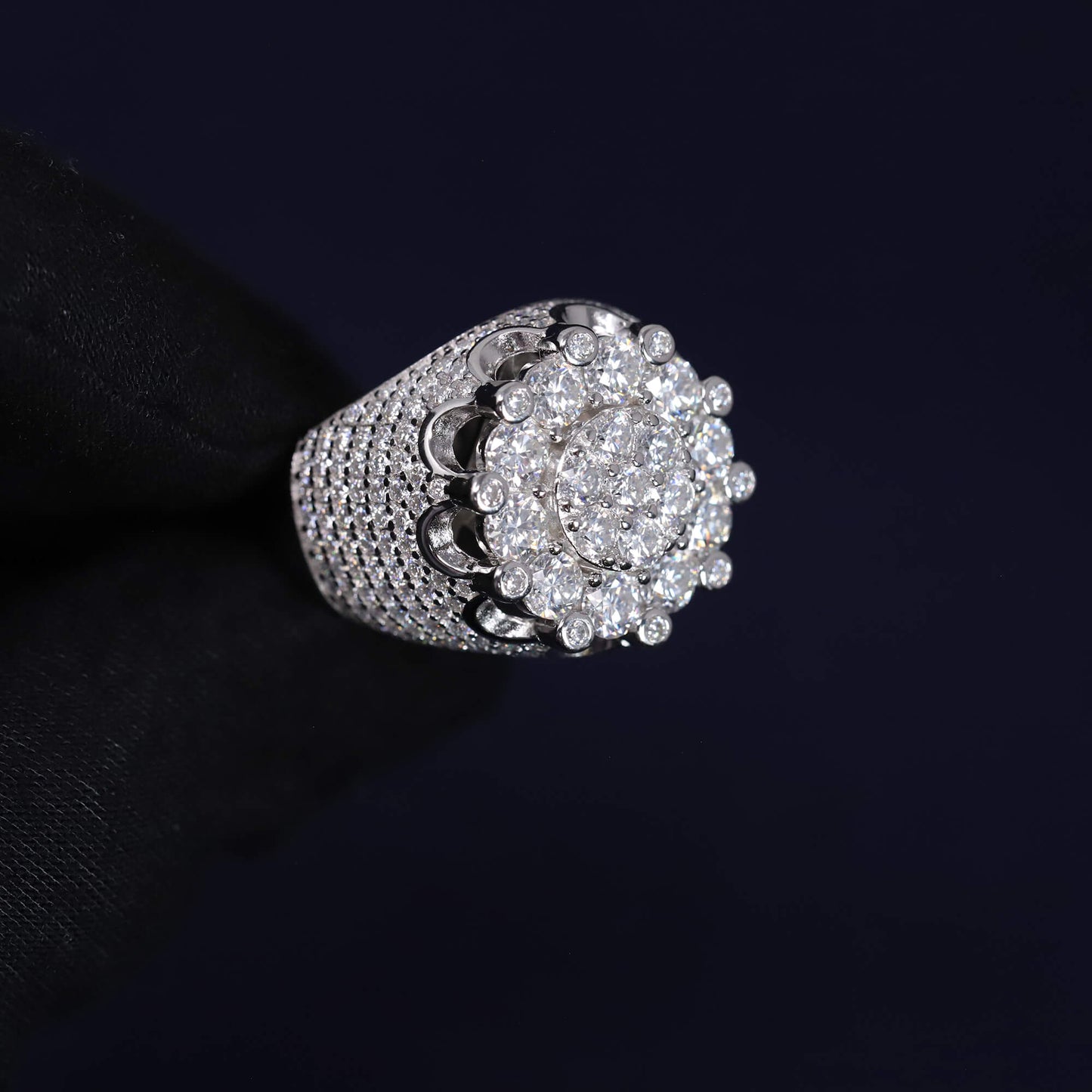 Silver ring with diamond cluster on a black background