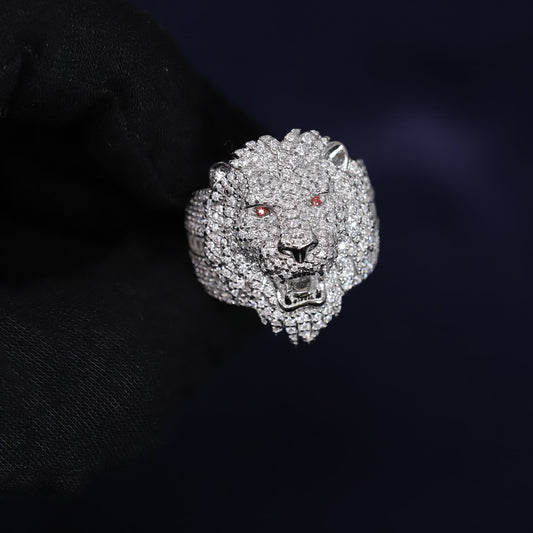 Silver lion head ring with gemstones on a dark background