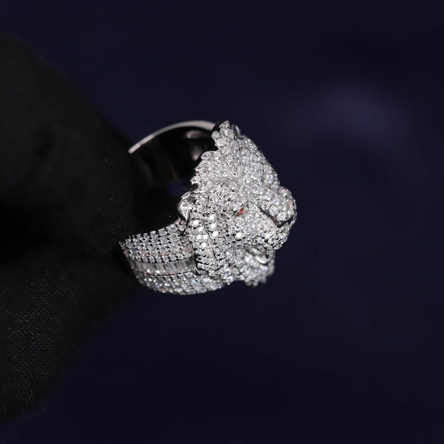 Silver lion head ring with intricate design on a black background