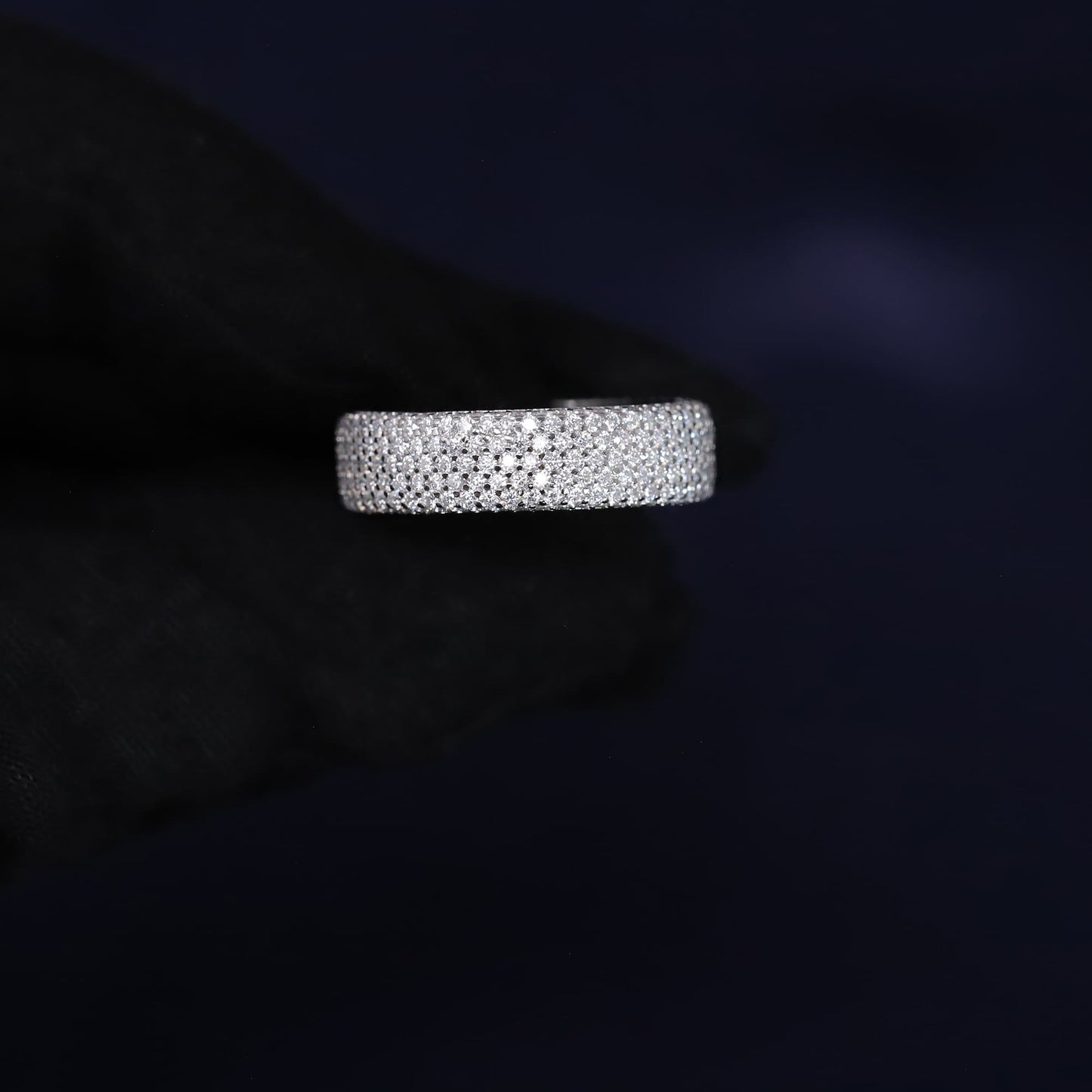Silver ring with small stones on a dark background