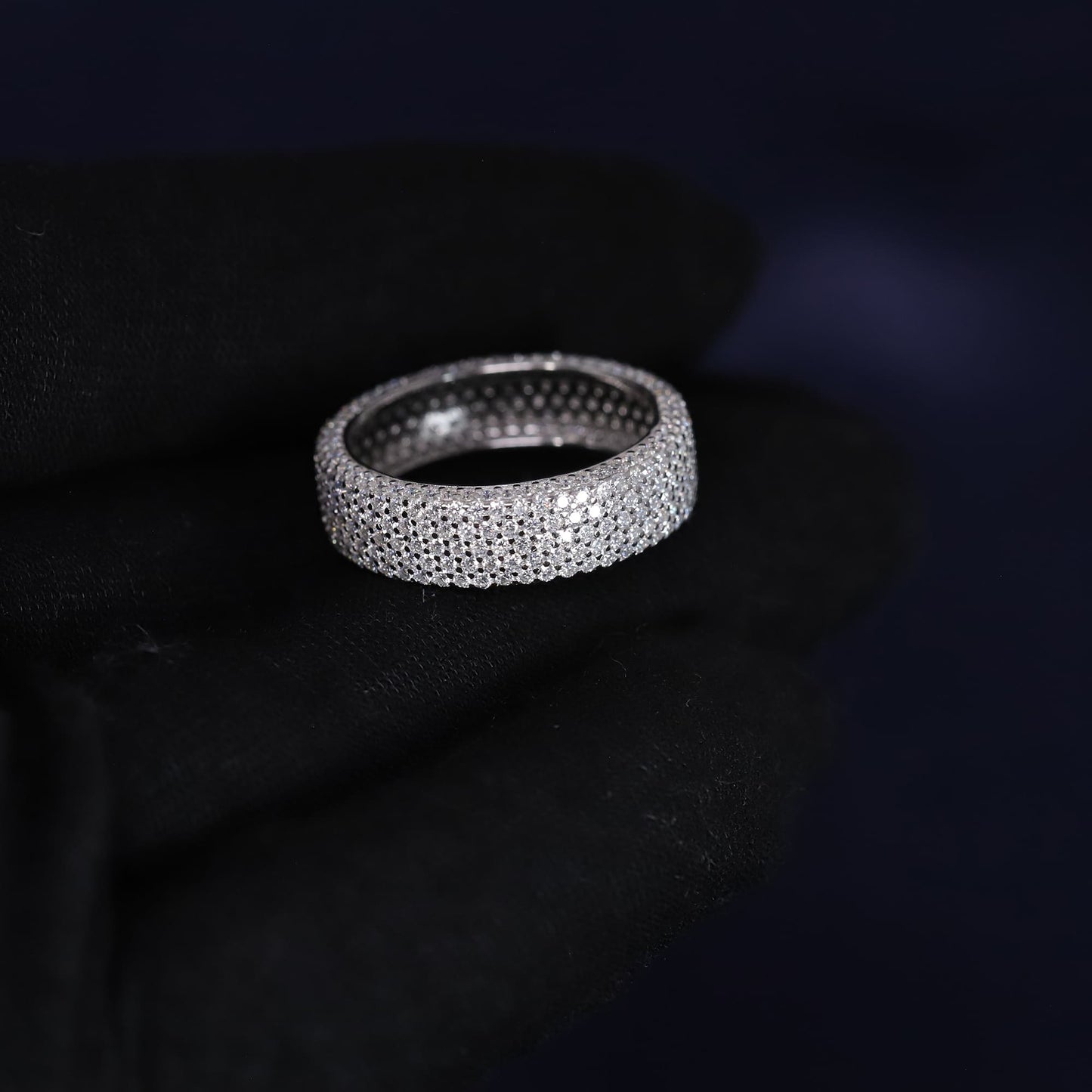 Silver ring with embedded stones on a dark background
