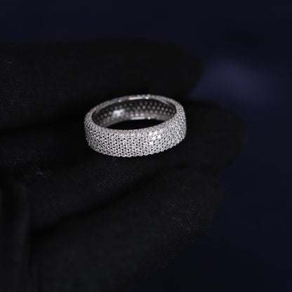 Silver ring with embedded stones on a dark background
