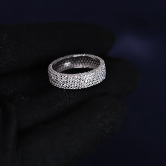 Silver ring with embedded stones on a dark background